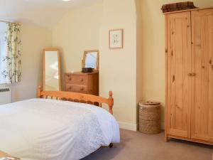 a bedroom with a bed and a dresser and a mirror at Westover Cottage in Wootton