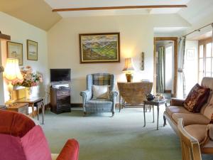 a living room with a couch and a tv at Rowan Tree Cottage - S4216 in Tulchan