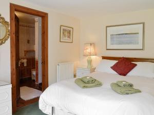 1 dormitorio con 1 cama con toallas en Rowan Tree Cottage - S4216, en Tulchan
