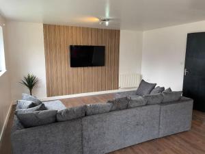sala de estar con sofá gris y TV de pantalla plana en Stunning Central Apartment With Free Parking, en Sheffield