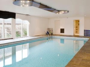 a large swimming pool with blue water in a house at Golf View in Lundie