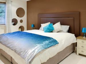 a bedroom with a large bed with a blue blanket at Golf View in Lundie