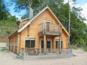 a log cabin with a deck and a balcony at Gairlochy Bay in Gairlochy