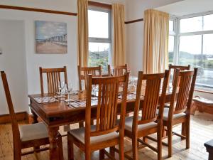 a dining room with a wooden table and chairs at Gwelfor in Trearddur