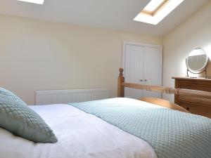 a bedroom with a bed with a mirror and a dresser at The Swallows - 28835 in Royal Wootton Bassett