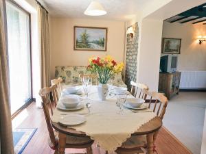 a dining room table with a white table cloth and flowers at Fox Cottage - E4510 in Chipping Sodbury