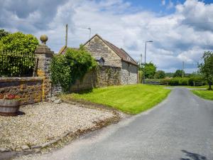 a house with a stone wall and a road at Fox Cottage - E4510 in Chipping Sodbury