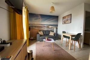 uma sala de estar com um sofá e uma mesa em Quiet apartment with balcony near the sea em Ouistreham