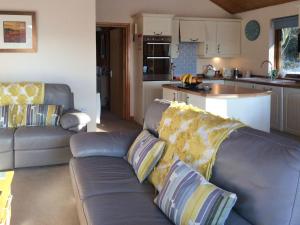 a living room with a couch and a kitchen at Larchwood in Ellonby