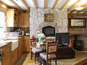 a kitchen with a table and a stone fireplace at Hen Wrych Hall Tower in Abergele