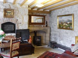 a living room with a stone fireplace and a tv at Hen Wrych Hall Tower in Abergele
