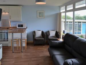 a living room with a couch and a table and a kitchen at High Tide - 30259 in Cromer