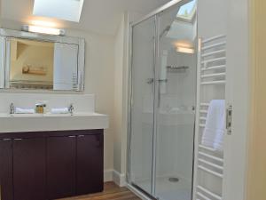 a bathroom with a glass shower and a sink at Casa Duran in Killin