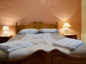 彭布羅克的住宿－The Quay，一间卧室配有一张带两个枕头和两个灯的床。