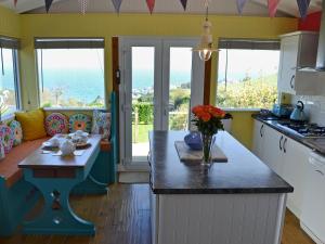 a kitchen with a counter with a table with flowers on it at The Gallery in Mevagissey