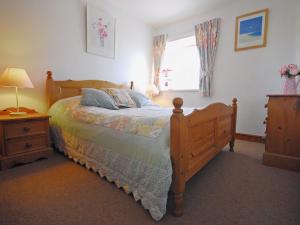 ein Schlafzimmer mit einem Holzbett und einem Fenster in der Unterkunft Robins Nest in Trevilley
