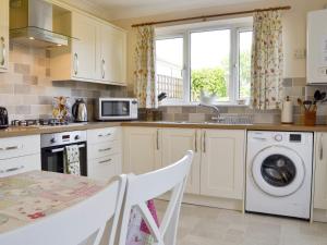 a kitchen with a sink and a washing machine at Rosedene in Bembridge