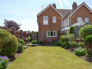 a brick house with a yard in front of it at Rosedene in Bembridge