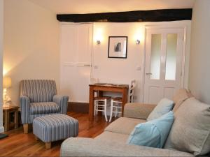 a living room with a couch and two chairs and a table at Old Town Cottage in Keswick