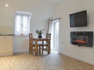 a kitchen and dining room with a table and a fireplace at Hollys Barn in Brent Knoll