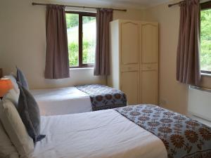 a hotel room with two beds and a window at Rosecraddoc Manor - Lakeview in Saint Cleer