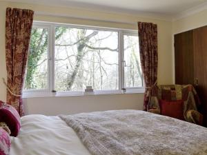 a bedroom with a bed and a large window at Rowans in Cleator