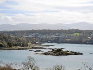 a bridge over a body of water with mountains in the background at Moriah - Hw7574 in Llanddeiniolen