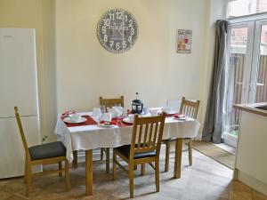 mesa de comedor con mantel y sillas blancas en Samphire en Cromer