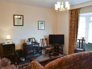 a living room with a couch and a tv at Gwenallt in Trevor