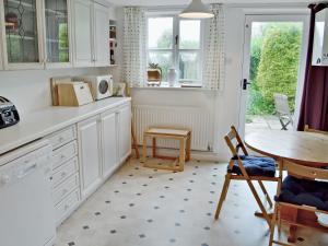 uma cozinha com armários brancos e uma mesa em Meadow Cottage-e1793 em Broadwindsor