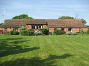 a brick house with a large yard in front of it at Stable Barn - 30954 in Thursford