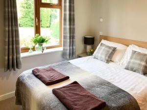 a bedroom with a large bed with two towels on it at Stable Barn - 30954 in Thursford