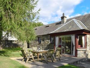 a patio with a table and chairs in front of a building at Tigh Na Bruaich in Kenmore