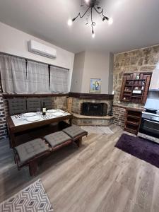 a living room with a table and a fireplace at TM Apartment No 1 - Rustic Style in Aridaia