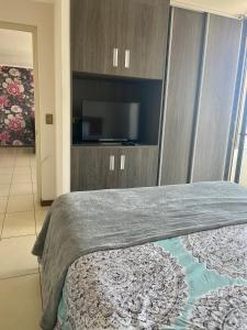 a bedroom with a bed with a flat screen tv at A pasos de cavancha in Iquique