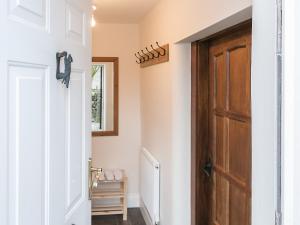 un pasillo con una puerta de madera en una casa en Manor Cottage, en Tideswell