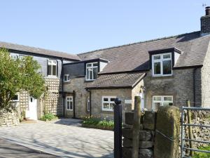 una antigua casa de ladrillo con entrada en Manor Cottage, en Tideswell