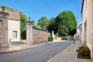 an empty street in a town with buildings and trees at Maison Laroze in Gevrey-Chambertin
