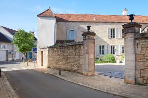 uma velha parede de tijolos ao lado de uma rua em Maison Laroze em Gevrey-Chambertin