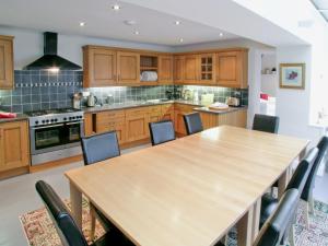 cocina con mesa de madera y sillas en Kings House, en Beaumaris