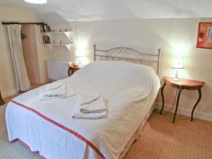 a bedroom with a white bed with two towels on it at Kings House in Beaumaris