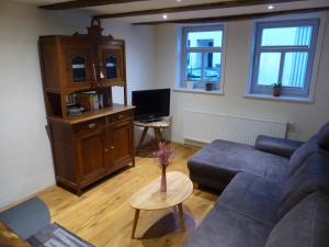 a living room with a couch and a tv at Ferienwohnung Schindewolf in Grebenstein