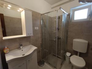 ein Bad mit einer Dusche, einem Waschbecken und einem WC in der Unterkunft Apartments Mira Krk in Krk