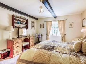 a bedroom with a bed and a dresser and a window at Coach House - E5120 in West Burton