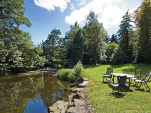 a table and chairs sitting next to a river at Coach House - E5120 in West Burton