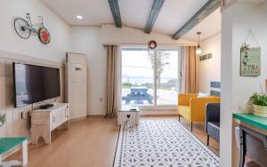 a living room with a flat screen tv and a couch at Soulmate Pension in Namhae