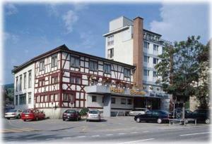 a large building with cars parked in a parking lot at Hotel Sonne in Altstätten