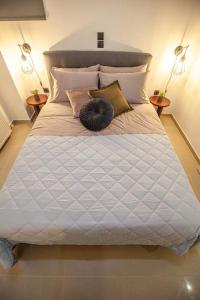 una gran cama blanca con un gato negro sobre ella en Kalafatis Downtown Apartment, en Itea