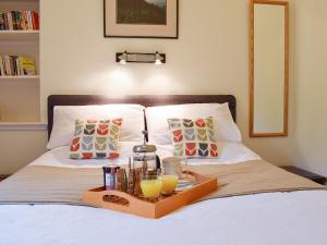 - un plateau de boissons et de jus de fruits sur un lit dans l'établissement Glebe Cottage, à New Scone