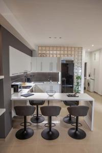 a kitchen with a large white island with bar stools at Kalafatis Downtown Apartment in Itea